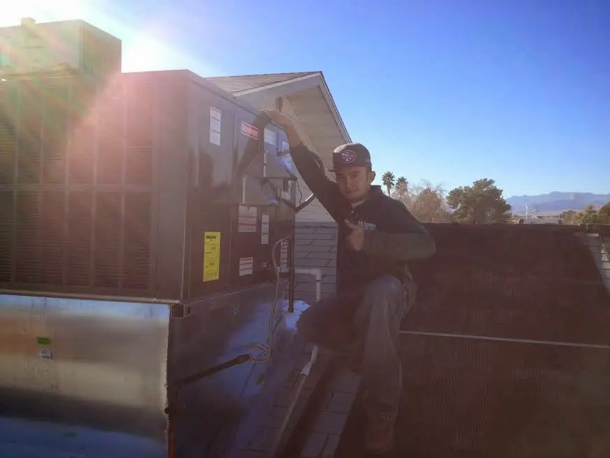 HVAC technician performing HVAC Inspection on a rooftop unit in Rifle